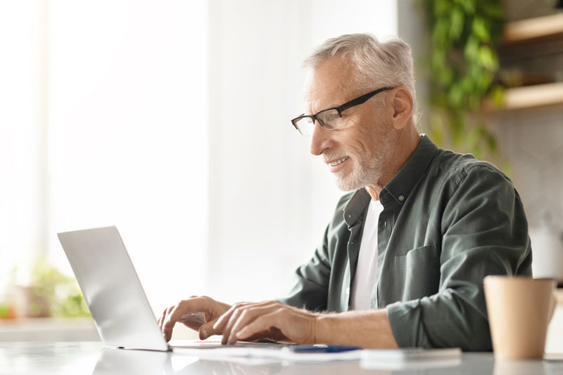 man checking sitting at laptop checking trust account statement